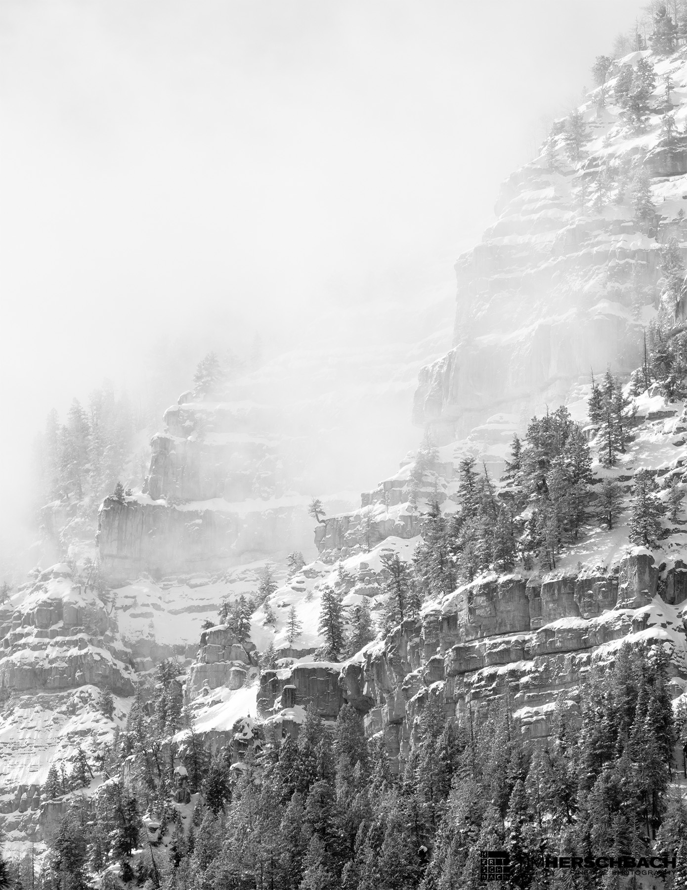 rocky bluff through clouds black and white photograph colorado